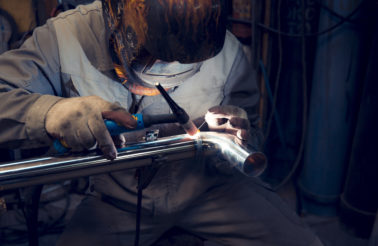 Man TIG welding a stainless steel pipe